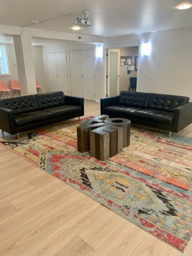 Sorority House lounge area with colorful area rug. 